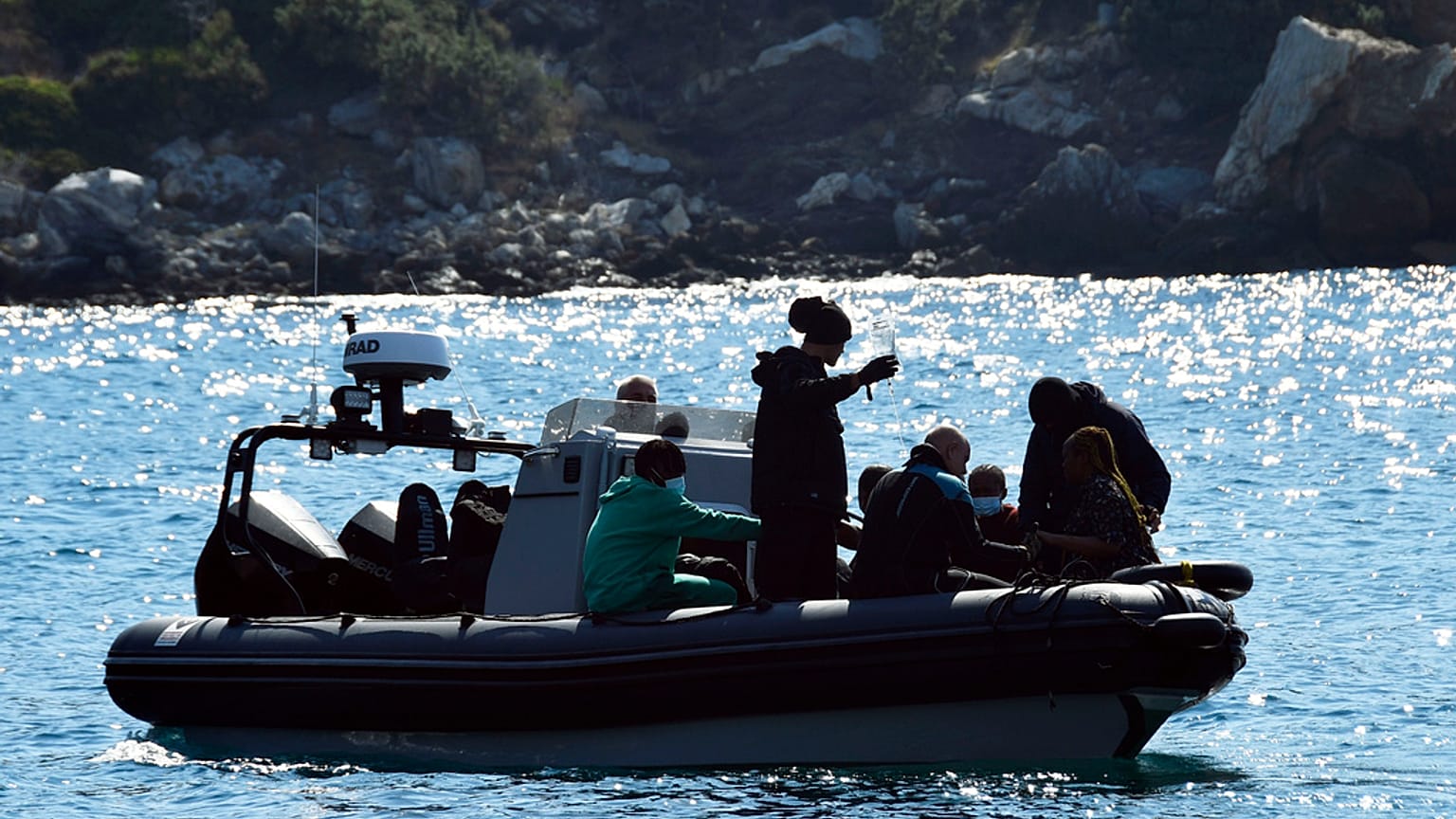 Yunanistan'ın doğu Ege Denizi'ndeki Samos adası açıklarında göçmenleri taşıyan bir tekne sorun yaşadıktan sonra, kurtulanlar bir botta oturuyor / 23 Eylül 2024 Pazartesi