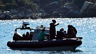 Yunanistan'ın doğu Ege Denizi'ndeki Samos adası açıklarında göçmenleri taşıyan bir tekne sorun yaşadıktan sonra, kurtulanlar bir botta oturuyor / 23 Eylül 2024 Pazartesi
