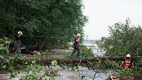 Feuerwehrleute arbeiten am Donnerstag, 19. September 2024, in der Nähe von Stronie Slaskie im Südwesten Polens an einer überfluteten Stelle.