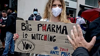 Архив: женщина с плакатом "Big pharma следит за вами" на кции протеста против вакцинных паспортов в Париже, Франция, август 2021 г.