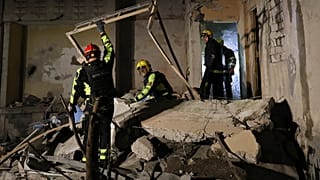 عمال خدمات الطوارئ ينقلون الأنقاض بعد غارة روسية على مبنى سكني في خاركيف، أوكرانيا