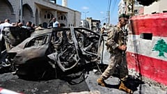 Ein libanesischer Soldat der geht an einem Auto vorbei, das von einem israelischen Angriff im Libanon, getroffen wurde, 21. August 2024.