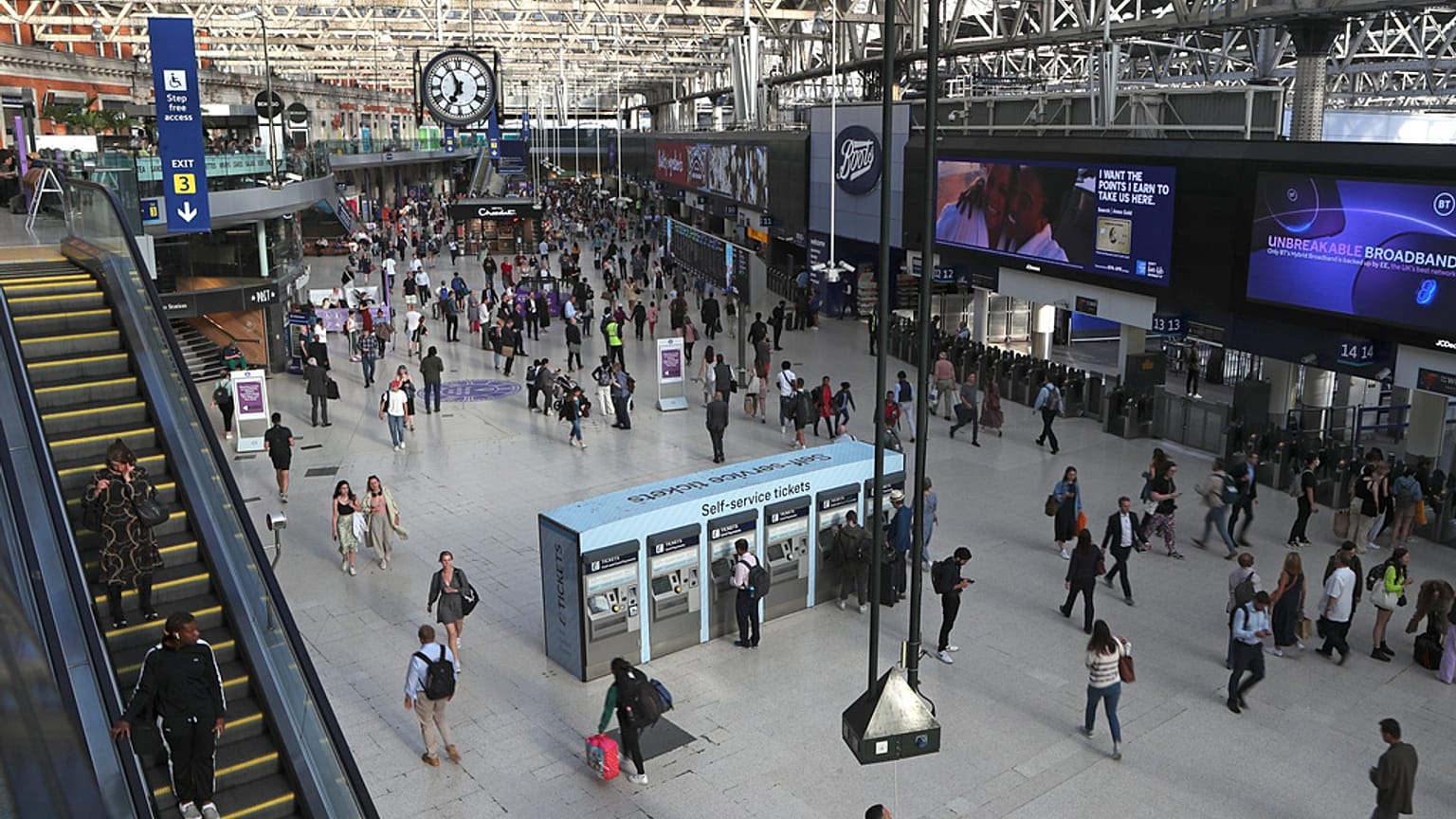 FILE -Commuters walk inside Waterloo station in London, June 20, 2022.
