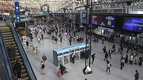 FILE -Commuters walk inside Waterloo station in London, June 20, 2022.