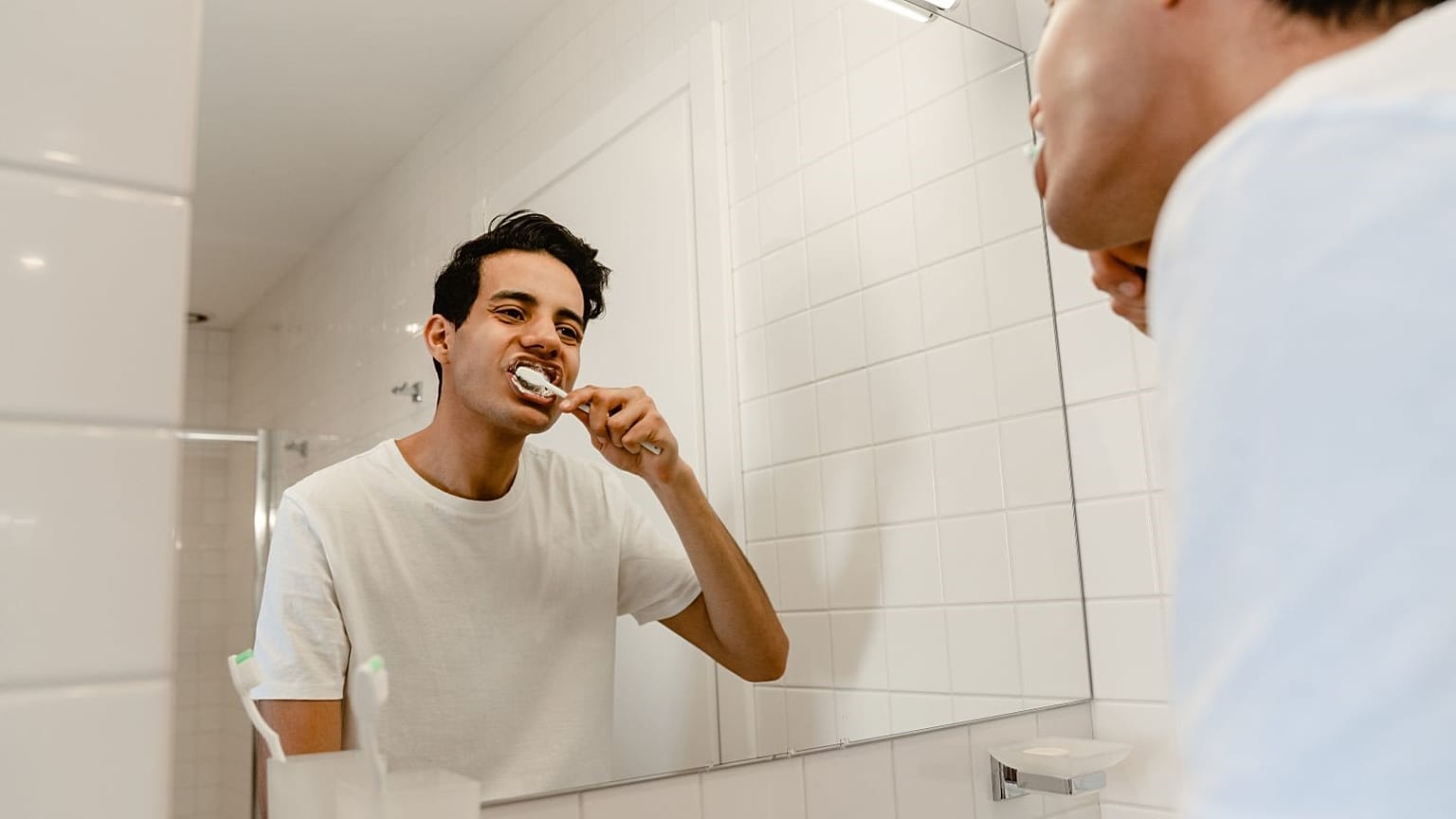 Um homem escova os dentes.
