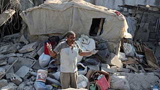 A man reacts as he stands on the rubble of a building hit in an Israeli airstrike in the southern Lebanese village of Akbieh..