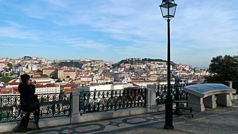 A woman takes a snapshot of the view from Sao Pedro de Alcantara Garden in Lisbon Dec. 22, 2008. 