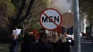 Les femmes installent un panneau d'interdiction d'accès pour les hommes.