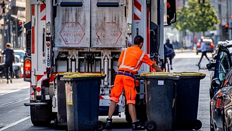 A garbage worker empties trash bins in Frankfurt, Germany, Wednesday, July 19, 2023. 