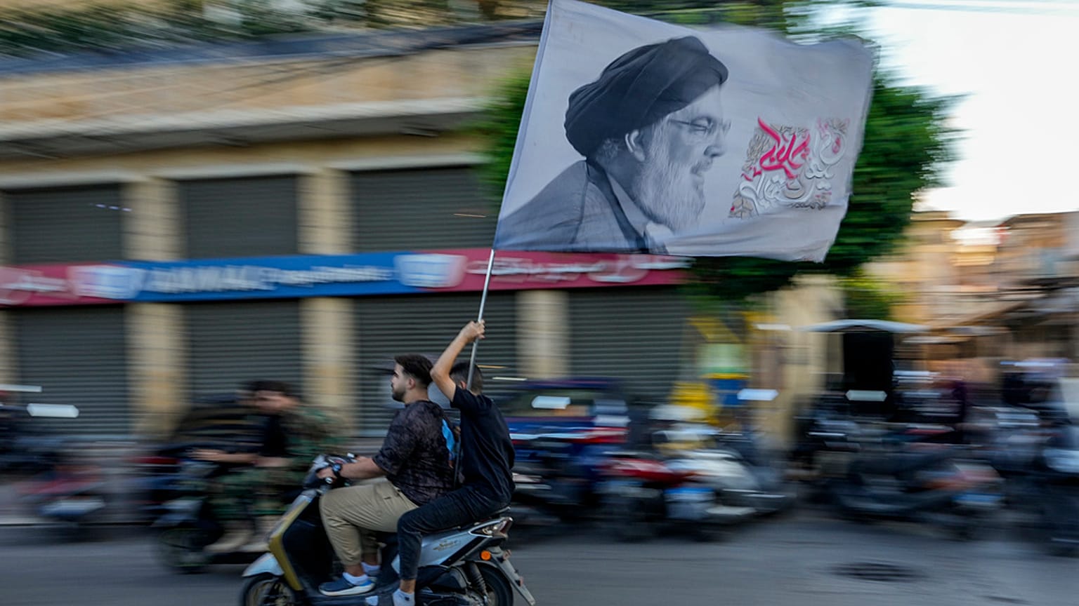Hizbullah destekçileri Hasan Nasrallah'ın resminin bulunduğu bayrak taşıyor, Beyrut, 25 Eylül 2024.