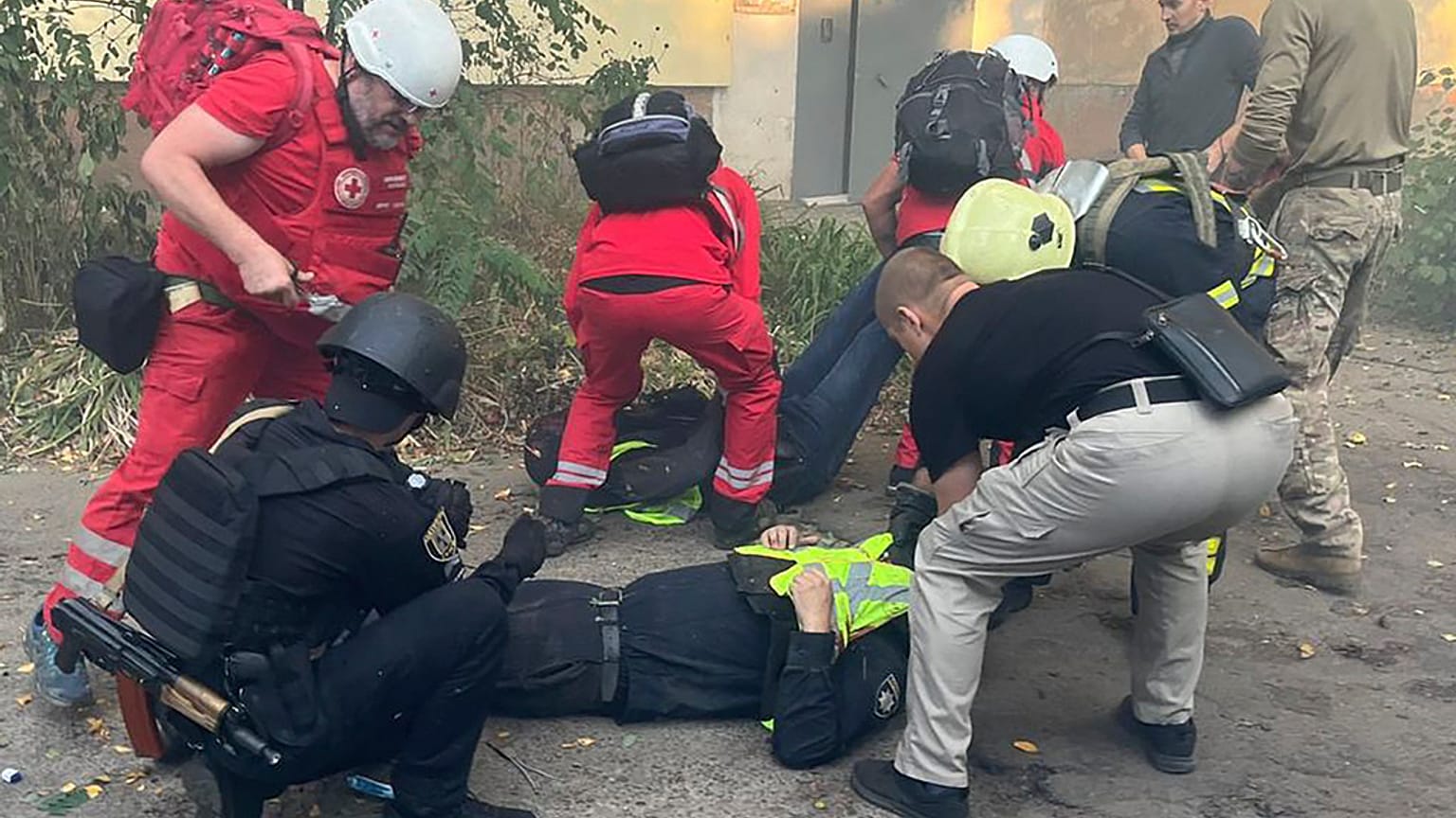Sürgősségi mentők segítenek egy sérült társuknak a szumi kórháznál