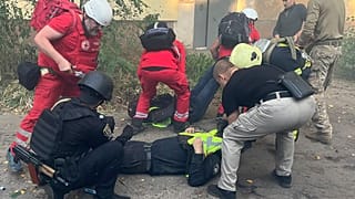 Sürgősségi mentők segítenek egy sérült társuknak a szumi kórháznál