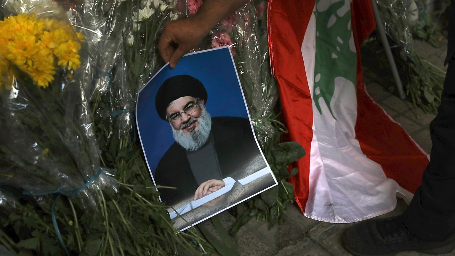 18 Eylül 2024 Çarşamba günü İran'ın Tahran kentindeki Lübnan Büyükelçiliği önündeki çiçek buketlerinin yanında Hizbullah lideri Hasan Nasrallah'ın posteri görüntüleniyor