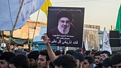 عراقيون يحملون صور زعيم حزب الله السيد حسن نصر الله الذي قُتل في غارة جوية إسرائيلية في بيروت، خلال جنازة رمزية بمدينة الصدر في بغداد