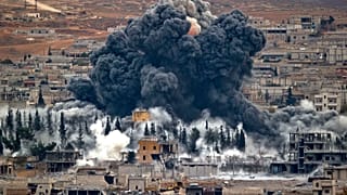 دخان يتصاعد من مدينة كوباني السورية، بعد غارة جوية للتحالف الذي تقوده الولايات المتحدة، من على قمة تل خارج سروج، على الحدود التركية السورية، مدينة كوباني، 17 نوفمبر 2014 