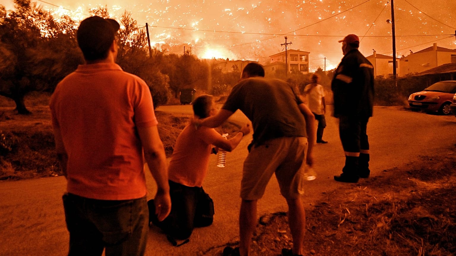 Un habitant réagit alors qu'un feu de forêt s'approche du village d'Ano Loutro, attisé par des vents violents, le 29 septembre 2024.