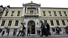 Pedestrians pass outside the headquarters of the National Bank of Greece in Athens. 30 October, 2015.