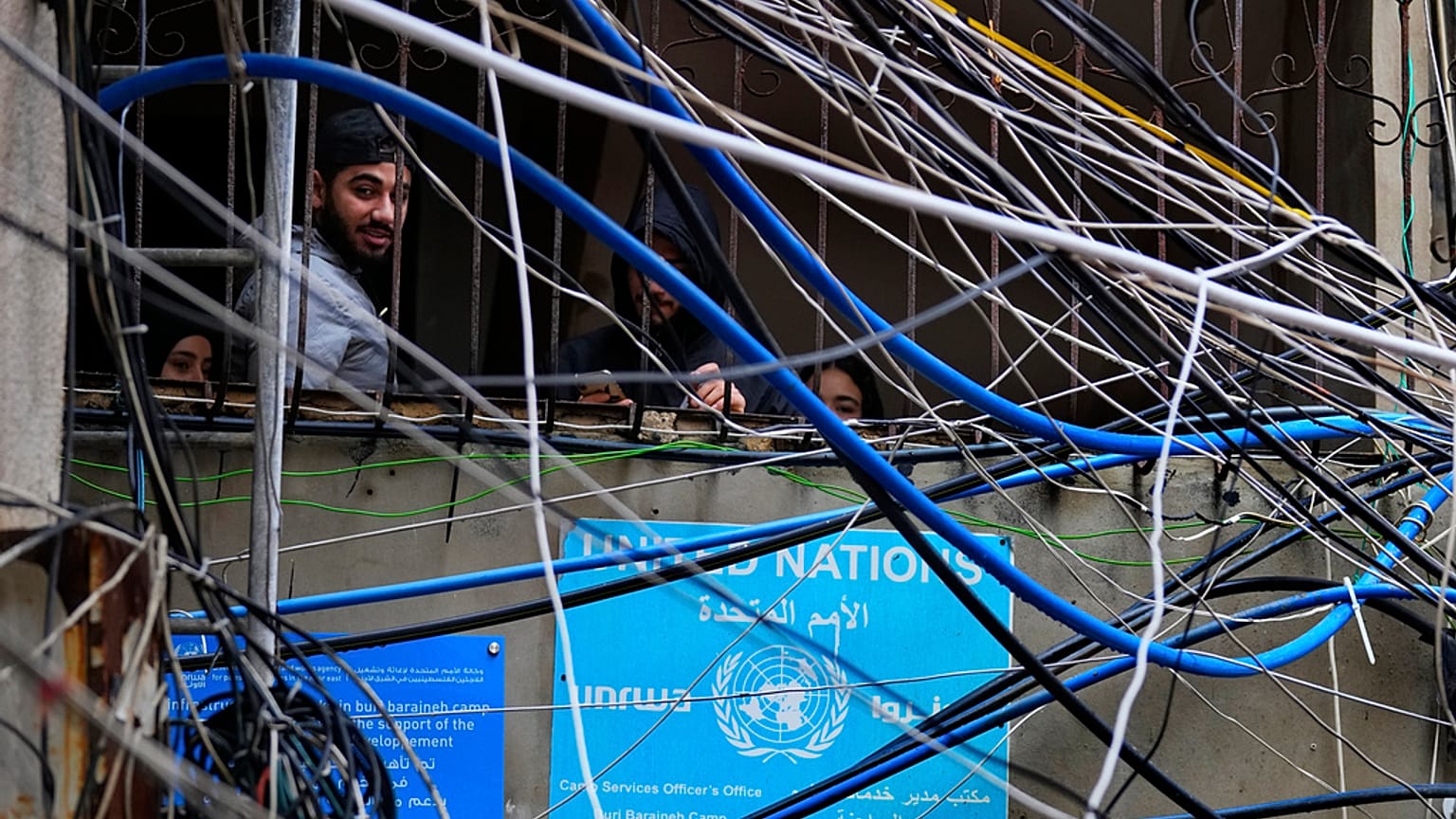 Filistinliler, Beyrut'un güneyindeki Bourj al-Barajneh Filistin mülteci kampında elektrik kabloları ve su borularının arasından bakıyor, 5 Şubat 2024.