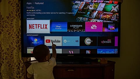 A child touches a TV screen.