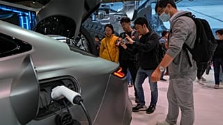 Visitors look at a Geely Galaxy E8 EV car model during the Auto China 2024 in Beijing. 28 April 2024.