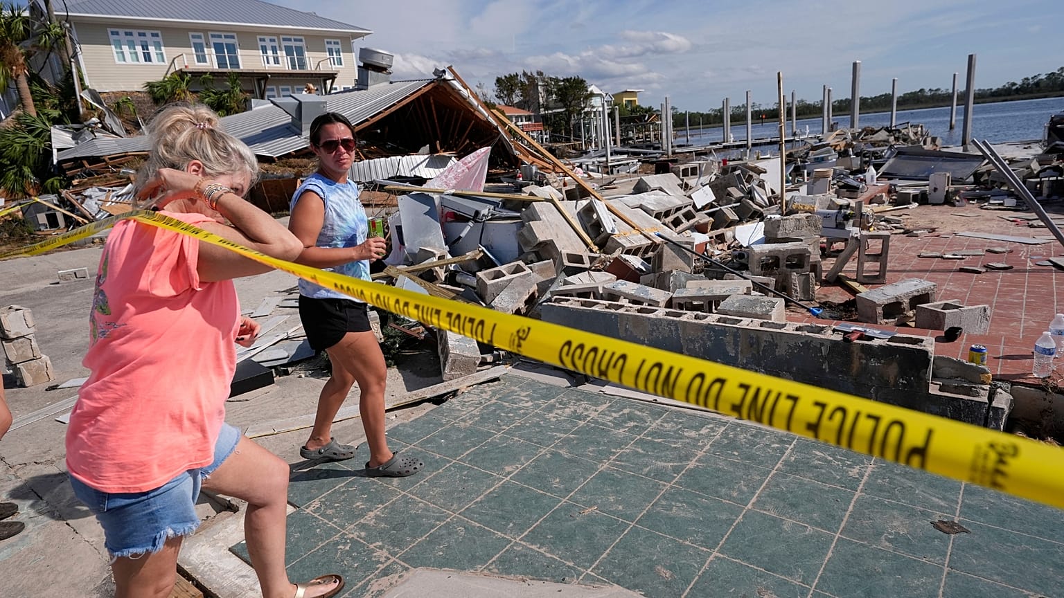 Owners and employees of Roy's Restaurant survey the business that was destroyed by the storm surge, in the aftermath of Hurricane Helene, Florida. 