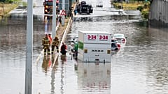 Firefighters work at a flooded road in Copenhagen, Sunday, Aug. 4, 2024. 