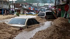 Veículos parcialmente submersos numa rua inundada após a passagem do furacão John em Acapulco, México, no sábado, 28 de setembro de 2024