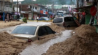 Veículos parcialmente submersos numa rua inundada após a passagem do furacão John em Acapulco, México, no sábado, 28 de setembro de 2024
