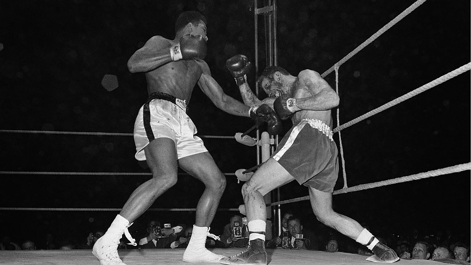 Muhammed Ali, solda, bir boks maçında İngiliz Henry Cooper'ın sol gözüne bir sol yumruk çıkarıyor atıyor, 1963