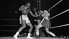 Muhammed Ali, solda, bir boks maçında İngiliz Henry Cooper'ın sol gözüne bir sol yumruk çıkarıyor atıyor, 1963
