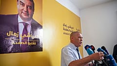 عبد الستار المسعودي، محامي المرشح الرئاسي التونسي العياشي الزامل، الذي يظهر على الملصق على الحائط، - تونس العاصمة، الاثنين 16 سبتمبر/أيلول 2024