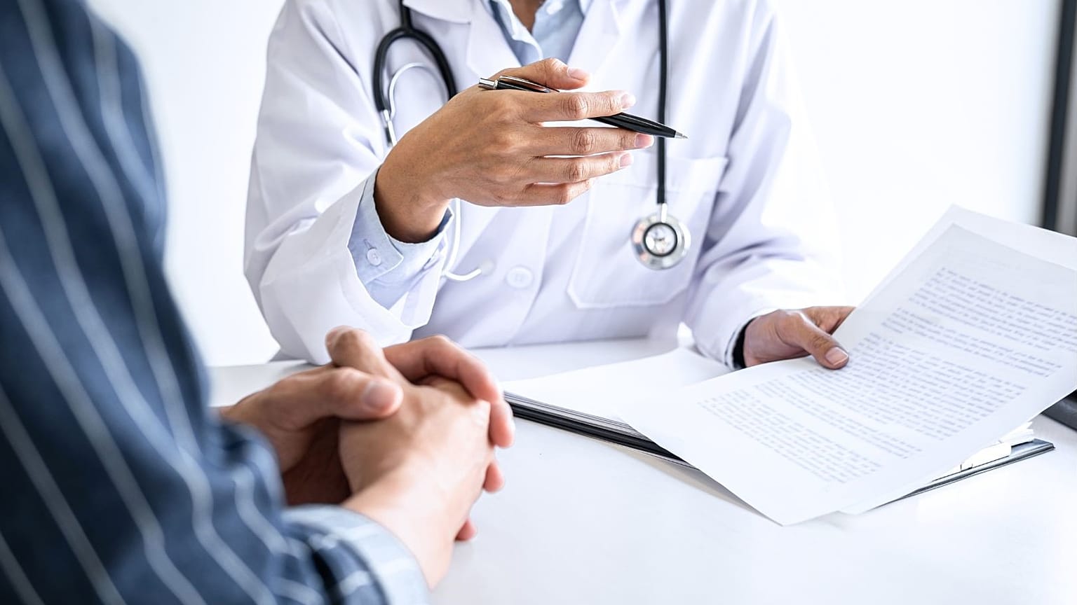 Un médico consulta a un paciente.