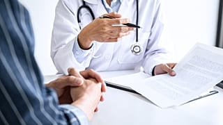 Um médico consulta um doente.