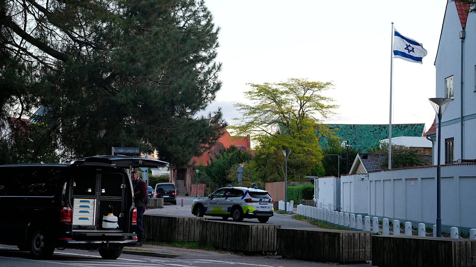 Egy rendőrautó látható a koppenhágai izraeli nagykövetség közelében, miközben a rendőrök két robbanást vizsgálnak a környéken.