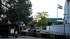 Egy rendőrautó látható a koppenhágai izraeli nagykövetség közelében, miközben a rendőrök két robbanást vizsgálnak a környéken.