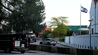 Um veículo da polícia é visto perto da embaixada israelita em Copenhaga enquanto os agentes investigam duas explosões na zona.