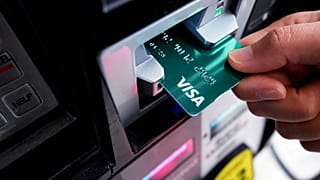 FILE - A customer uses a Visa credit card to pay for gasoline at a gas station in Mundelein, Ill., Feb. 8, 2024.