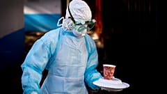 Архивное фото: медицинский работник в полном защитном снаряжении несёт еду в изоляционную палатку во время вспышки вируса в 2014 году, Найроби, Кения. 