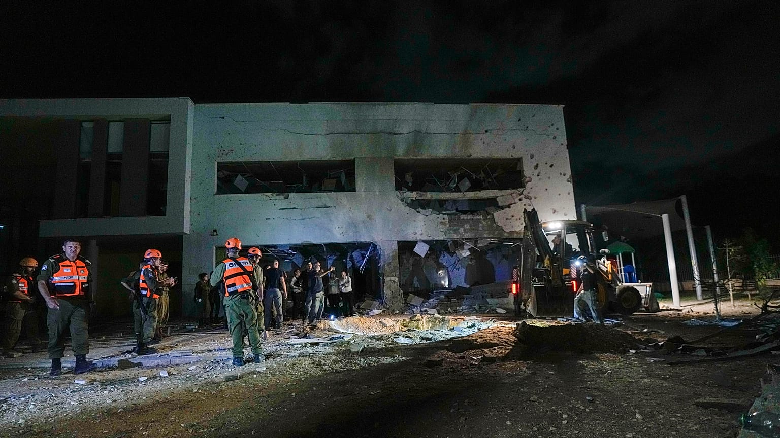 Militari e polizia israeliani lavorano presso un edificio scolastico danneggiato e colpito da missili lanciati dall'Iran a Gadera, in Israele.