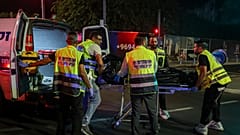 Zaka Kurtarma Ekibi personeli, Tel Aviv'deki terör saldırısı sonrası bir maktulü sedye ile ambulansa taşıyor, 1 Ekim 2024