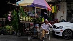 بائع متجول فلسطيني يجلس بجانب عربته المحملة بالخضروات أثناء انتظار العملاء، في مدينة نابلس بالضفة الغربية، الاثنين، 16 سبتمبر، 2024.