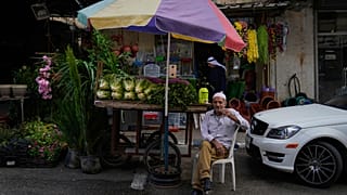 بائع متجول فلسطيني يجلس بجانب عربته المحملة بالخضروات أثناء انتظار العملاء، في مدينة نابلس بالضفة الغربية، الاثنين، 16 سبتمبر، 2024.