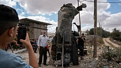 Des Palestinien se prennent en photo devant les débris d'un missiles iraniens à Hébron, Cisjordanie (AP Photo/Mahmoud Illean)