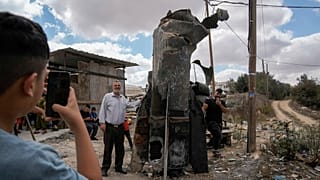 Des Palestinien se prennent en photo devant les débris d'un missiles iraniens à Hébron, Cisjordanie (AP Photo/Mahmoud Illean)