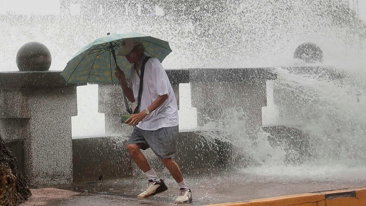 Un hombre huye de las olas a lo largo de la costa en Kaohsiung, sur de Taiwán, el miércoles 2 de octubre de 2024.