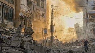 Lübnan'ın başkenti Beyrut yakınlarındaki Dahiyeh'te gerçekleştirilen İsrail hava saldırısının ardından yükselen dumanlar arasında bir adam siper almaya çalışıyor, 4 Ekim 2024.