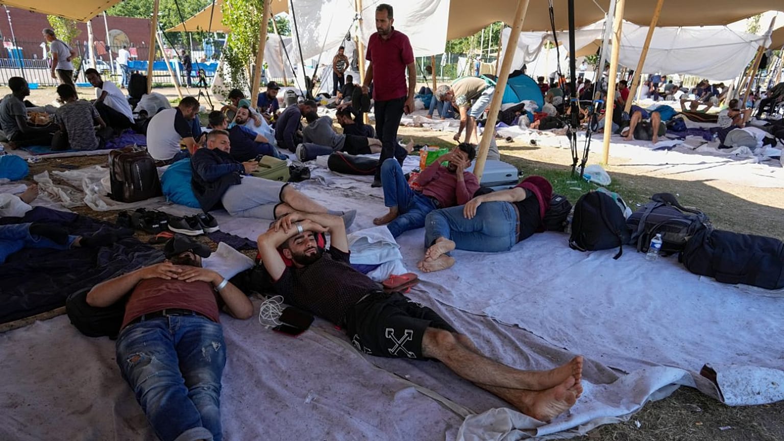 Μετανάστες αναζητούν καταφύγιο έξω από ένα υπερπλήρες κέντρο αιτούντων άσυλο στο Ter Apel, στη βόρεια Ολλανδία, Πέμπτη 25 Αυγούστου 2022. 