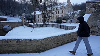 Una persona camina por la nieve junto al Chateau du Pont en Louveciennes, al oeste de París.