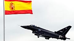 Un Eurofighter vuela cerca de una bandera de España durante un ensayo