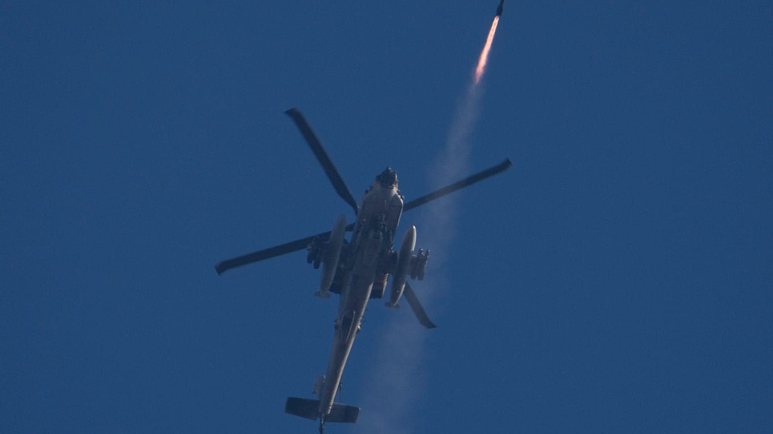 Un hélicoptère Apache israélien tire un missile vers le sud du Liban, vu depuis le nord d'Israël, vendredi 4 octobre 2024.